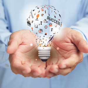 Manos sujetando una bombilla con ideas. Cogni-Focus Lamberts